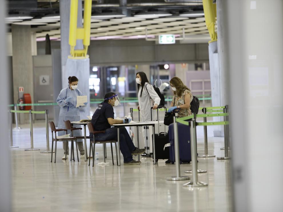 Varios pasajeros llegan al aeropuerto de Barajas procedentes de Colombia este sabado en Madrid.