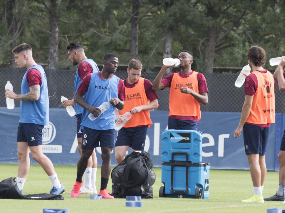 Los jugadores de la SD Huesca se hidratan durante el entrenamiento del miércoles.