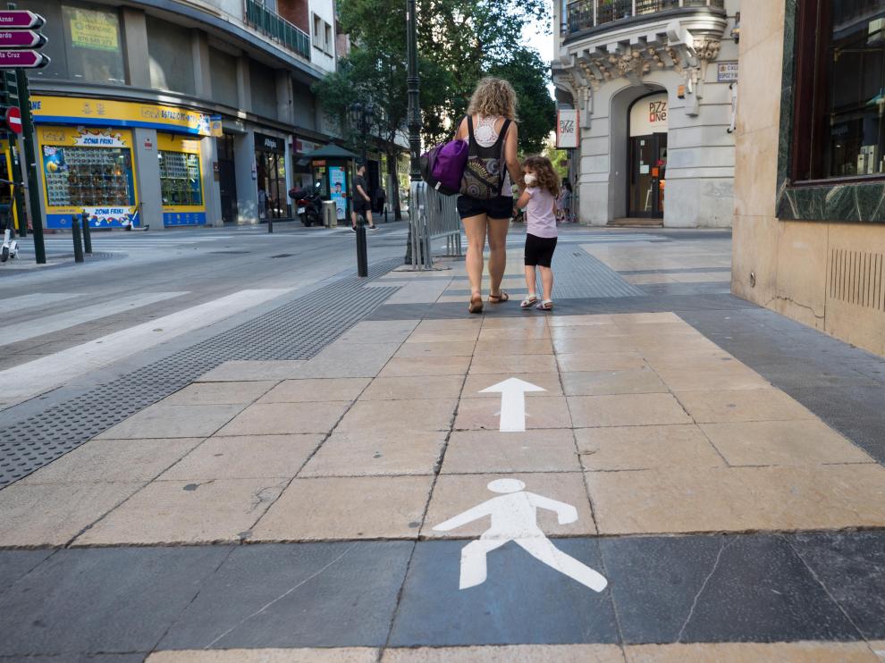 La señalización en las aceras ayuda a los ciudadanos a mantener los dos metros de distanciamiento entre las personas por la calle.