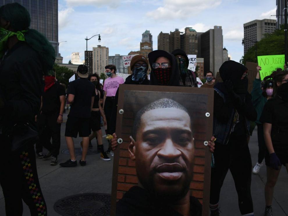 Un manifestante en Detroit con un cartel con el rostro de Georges Floyd, muerto a manos de la Policía,