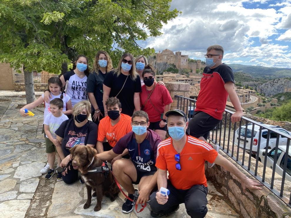 Miguel Ángel Gómez y su familia, haciendo turismo con mascarillas, con la colegiata de Alquézar al fondo.