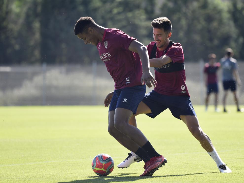 Carlos Kevin intenta avanzar con el balón ante la presión de Juan Carlos, en un entrenamiento de la SD Huesca.