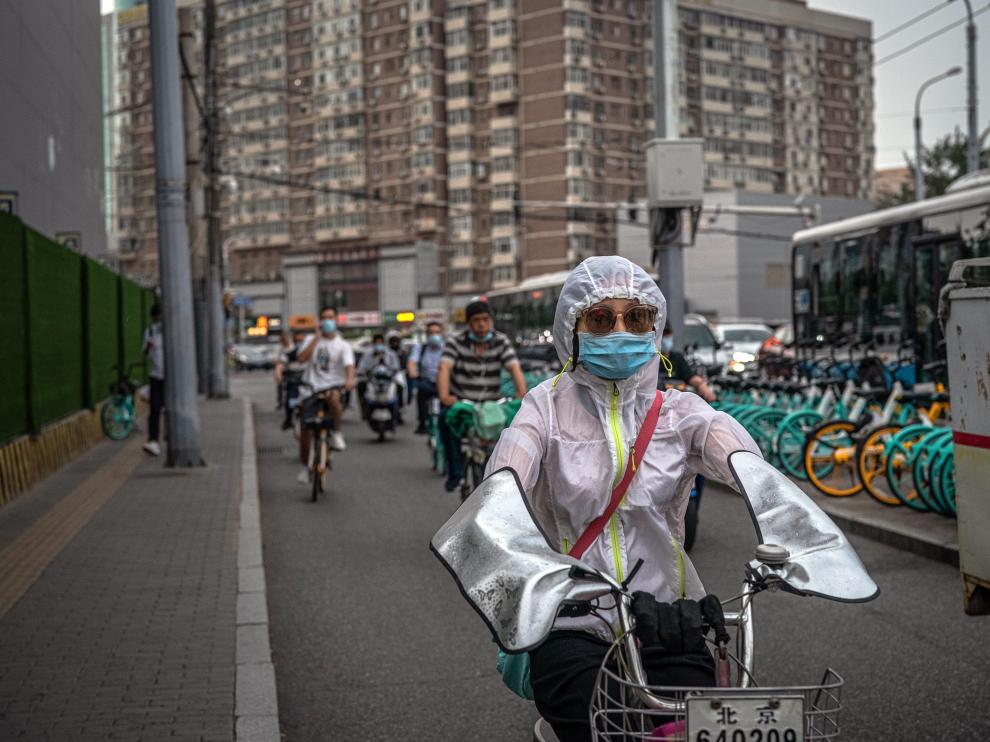 Beijing (China), 18/06/2020.- A woman wearing a protective face mask rides a scooter during an evening rush hour, in Beijing, China, 18 June 2020. Chinese health authorities said that they received reports of 28 new confirmed COVID-19 cases on 17 June of which 21 cases were reported in Beijing. Authorities gave COVID-19 nucleic acid tests to 356,000 people since 13 June, according to the city's government officials, as the number of new coronavirus cases is continuing to increase in the city. EFE/EPA/ROMAN PILIPEY The new coronavirus outbreak in Beijing
