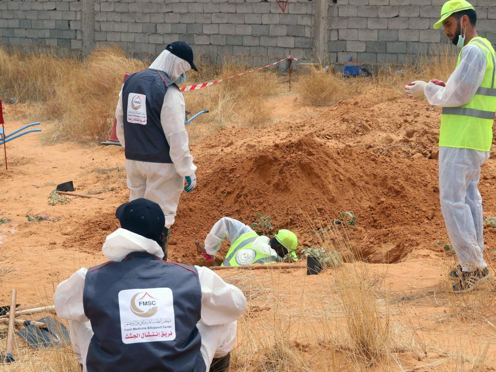 Búsqueda de restos humanos en unas recientes exhumaciones en Libia.