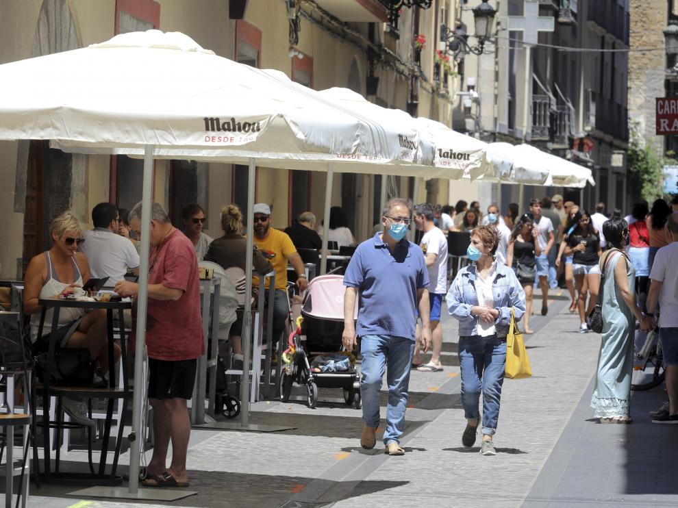 Turistas paseando por Jaca con la mascarilla puesta.