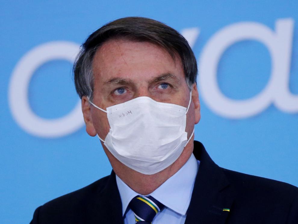 FILE PHOTO: Brazil's President Jair Bolsonaro wearing a protective mask looks on during the launching ceremony of the Plano Safra 2020/2021, action plan for the agricultural sector, in Brasilia