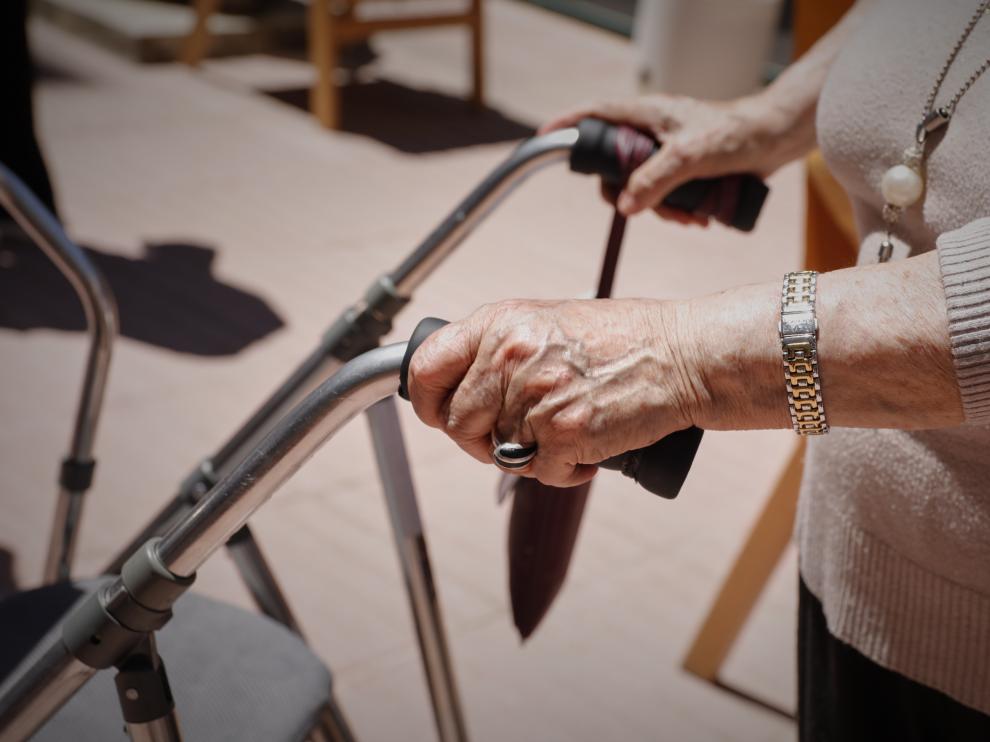 Una anciana con un andador en una residencia.