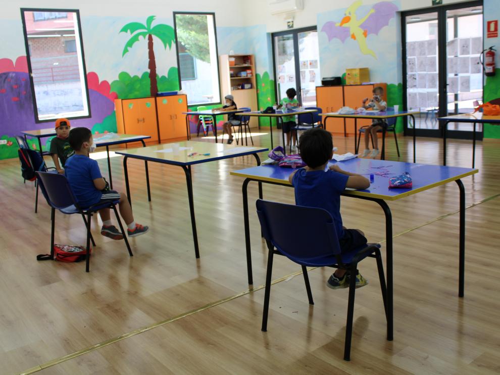 Varios niños pintando en la ludoteca el primer día de los talleres de verano.