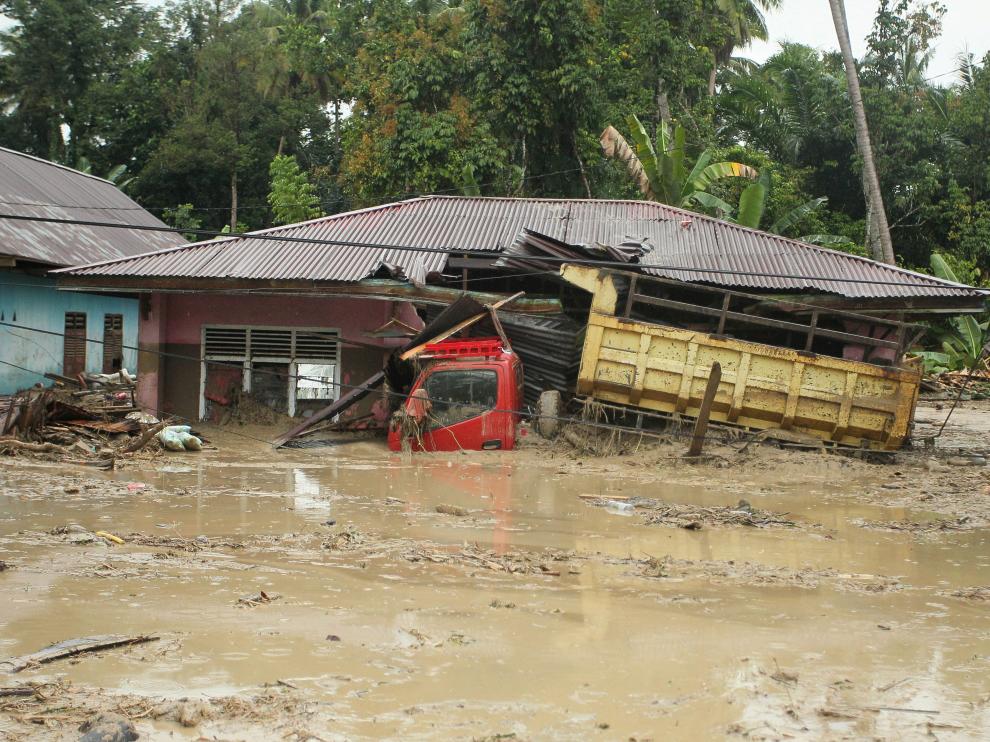 A truck is submerged in mud after flash floods swept through Radda Village, as several people were killed and dozens remain missing in North Luwu in Sulawesi