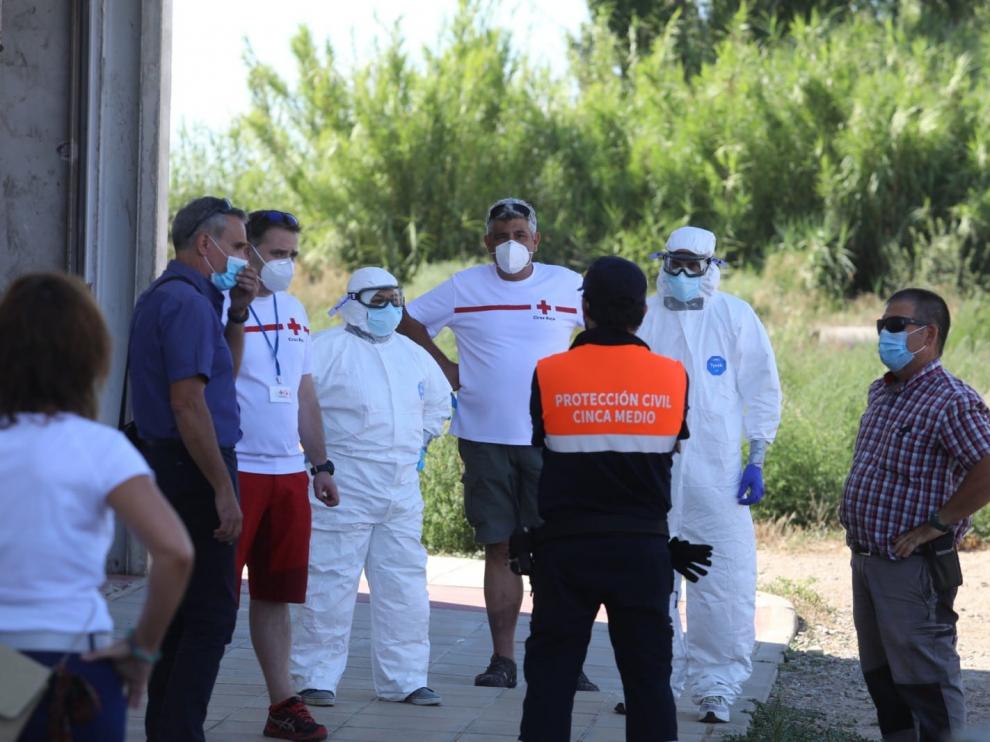 Operativo establecido en Albalate de Cinca para el traslado de los temporeros contagiados del asentamiento ilegal al polideportivo.