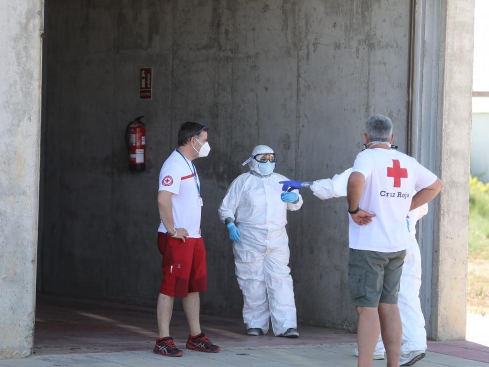 Operativo establecido en Albalate de Cinca para el traslado de los temporeros contagiados del asentamiento ilegal al polideportivo.