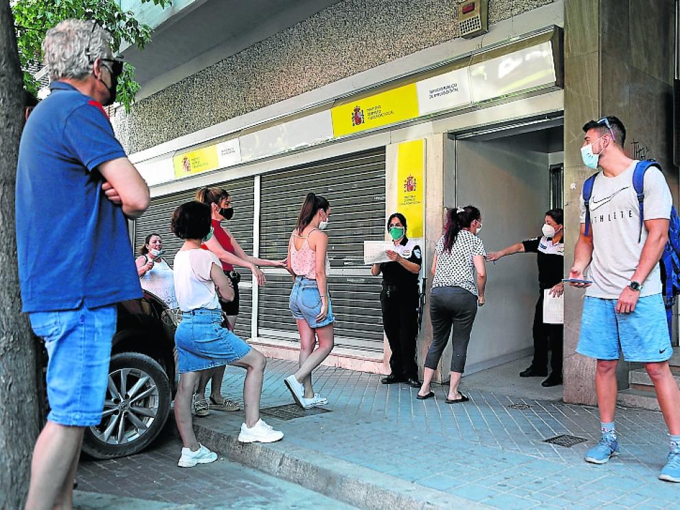 Trabajadores guardan fila ante una oficina del SEPE.