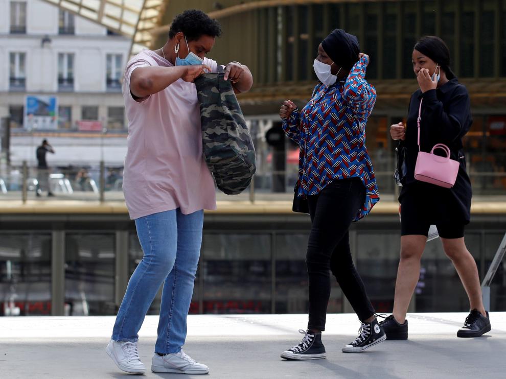 Tres personas con mascarilla, en una zona comercial del centro de París, este jueves.