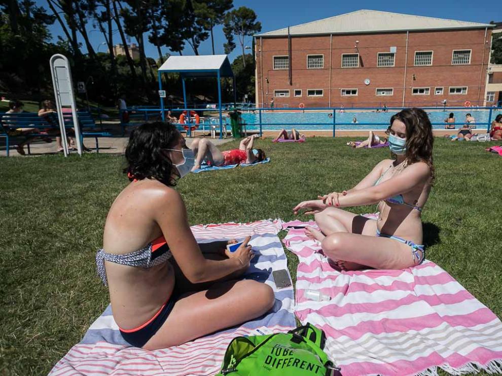 Dos usuarias del C. D. M. Salduba de Zaragoza disfrutaron ayer del sol con mascarilla.