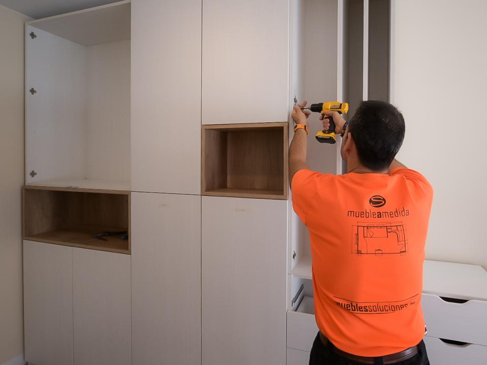 Un empleado de Muebles Soluciones, durante el montaje de un armario.