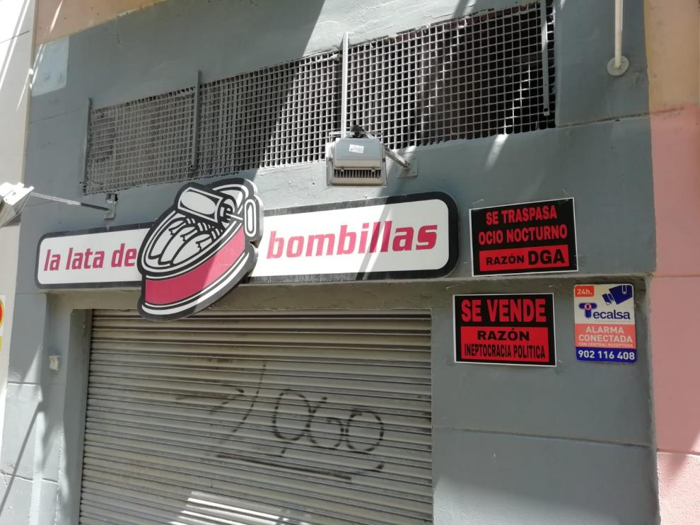 Dos carteles en la Lata de Bombillas de la campaña para reclamar ayudas de las instituciones.