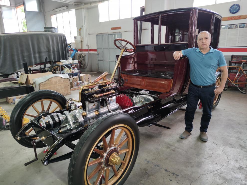 Ángel Martínez, junto al Renault Coupé Chauffer EF de 1911 que está restaurando actualmente junto a sus hijos. AAA
