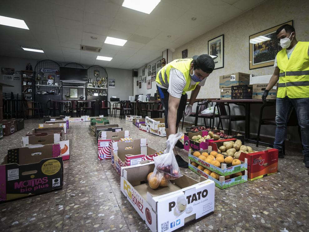 Las cajas con la comida ocupan el suelo del salón social de la sede de la Asociación de Vecinos Cívitas.