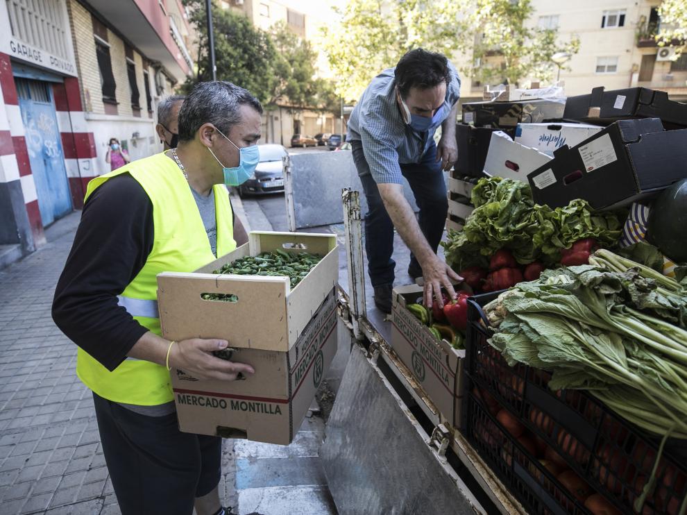Voluntarios de la Asociación de Vecinos Cívitas del barrio de Las Fuentes descargan el camión con los alimentos este pasado viernes.