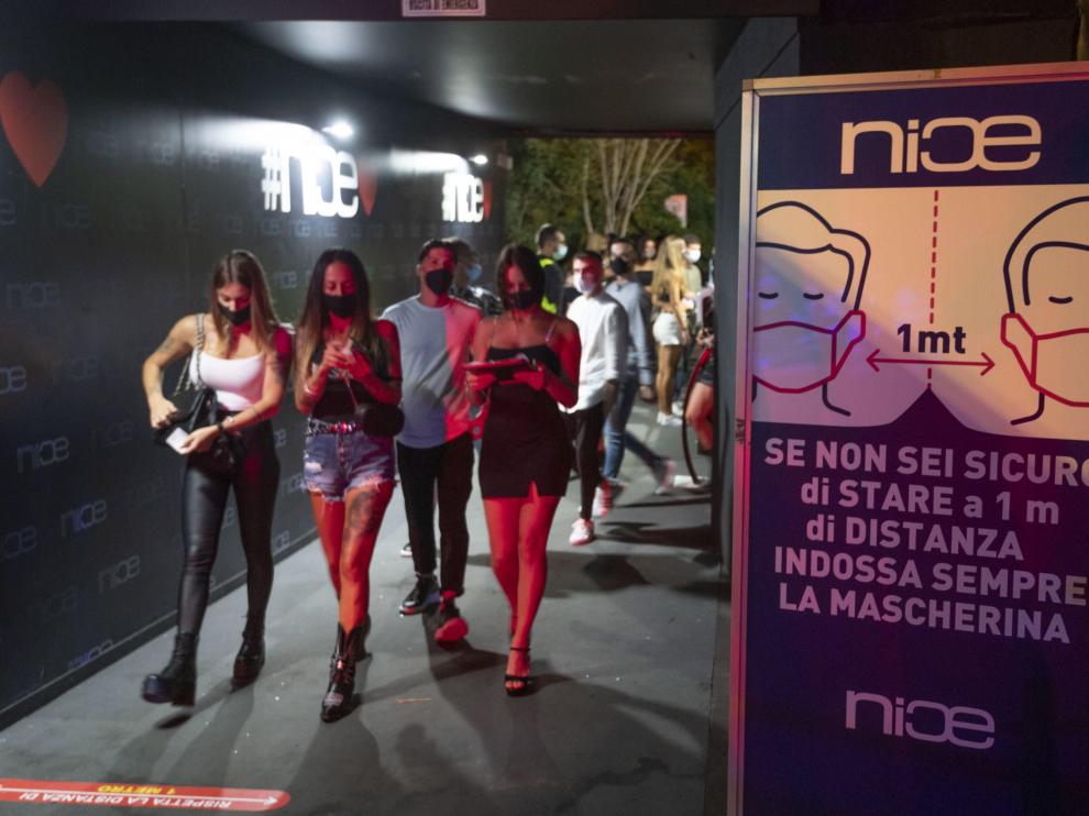 Jóvenes acceden a una discoteca con mascarilla el 15 de agosto en Roma.