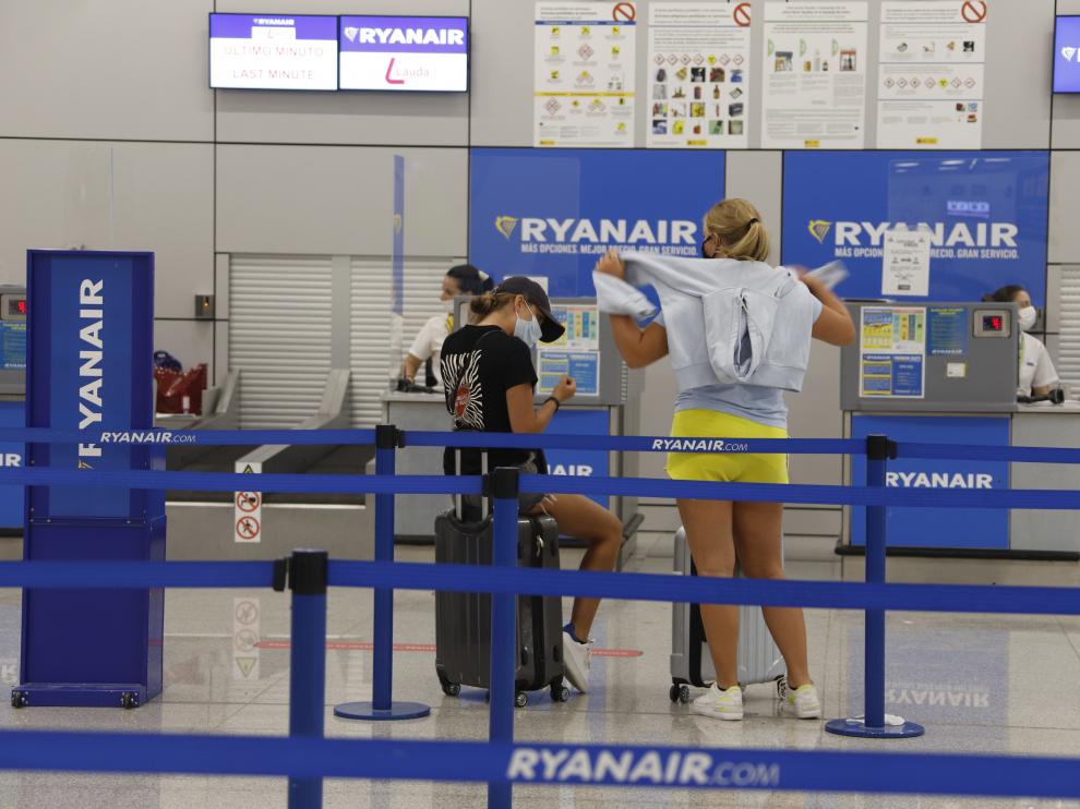Dos jóvenes esperan a hacer el check in con la compañía Ryanair, este martes en el aeropuerto de Palma de Mallorca.