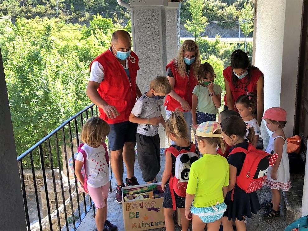 Los niños y niñas de la Escuela de Verano de Ansó entregan los alimentos a Cruz Roja.