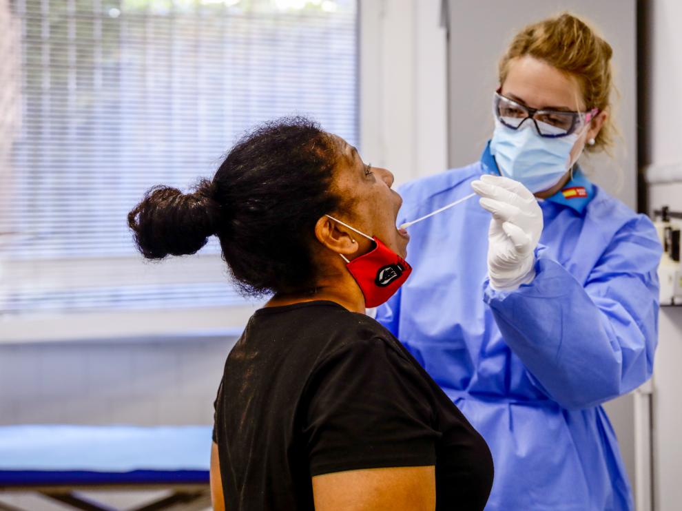 Una trabajadora sanitaria protegida realiza un test a una mujer en Villaverde, en Madrid este miércoles.