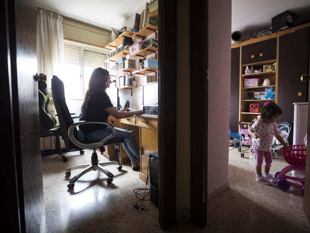 Imagen de archivo de una madre aragonesa teletrabajando durante la pandemia con su hija al lado
