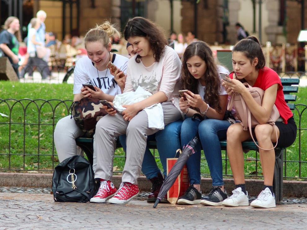 Grupo de adolescentes mirando el móvil.