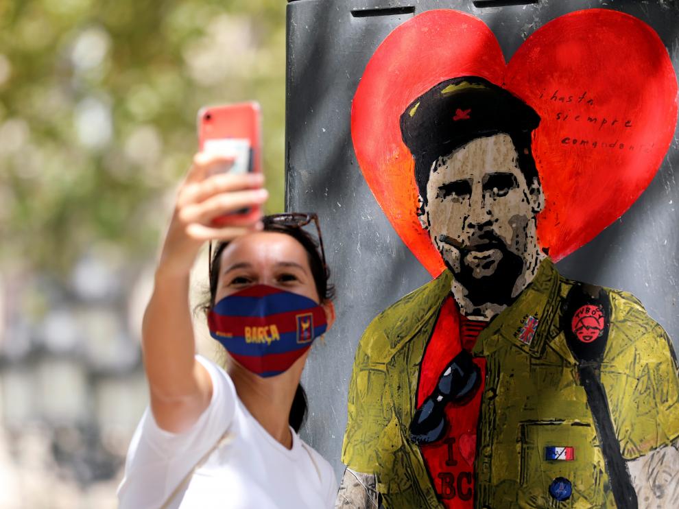 Una mujer se toma un serfi con un mural del astro argentino en Barcelona