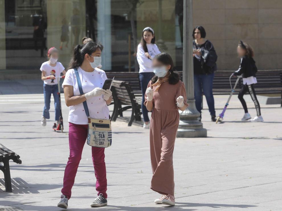 Una niña paseando por las calles de Huesca con mascarilla