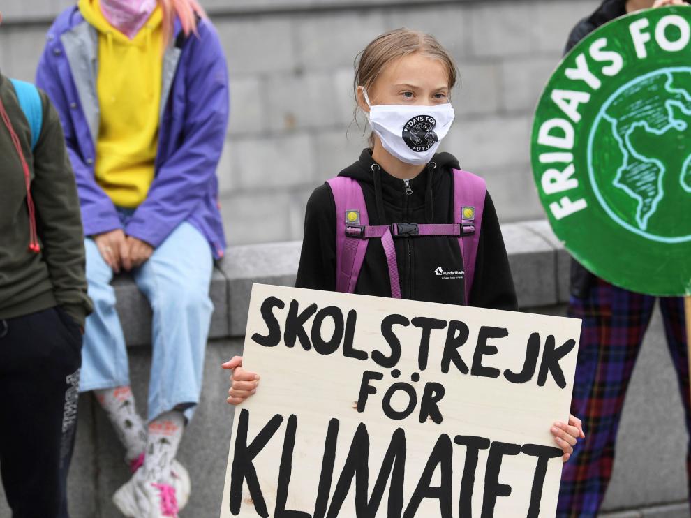 Greta Thunberg sostiene un cartel que dice 'Huelga escolar por el clima' durnate una protesta frente al Parlamento sueco, en Estocolmo.
