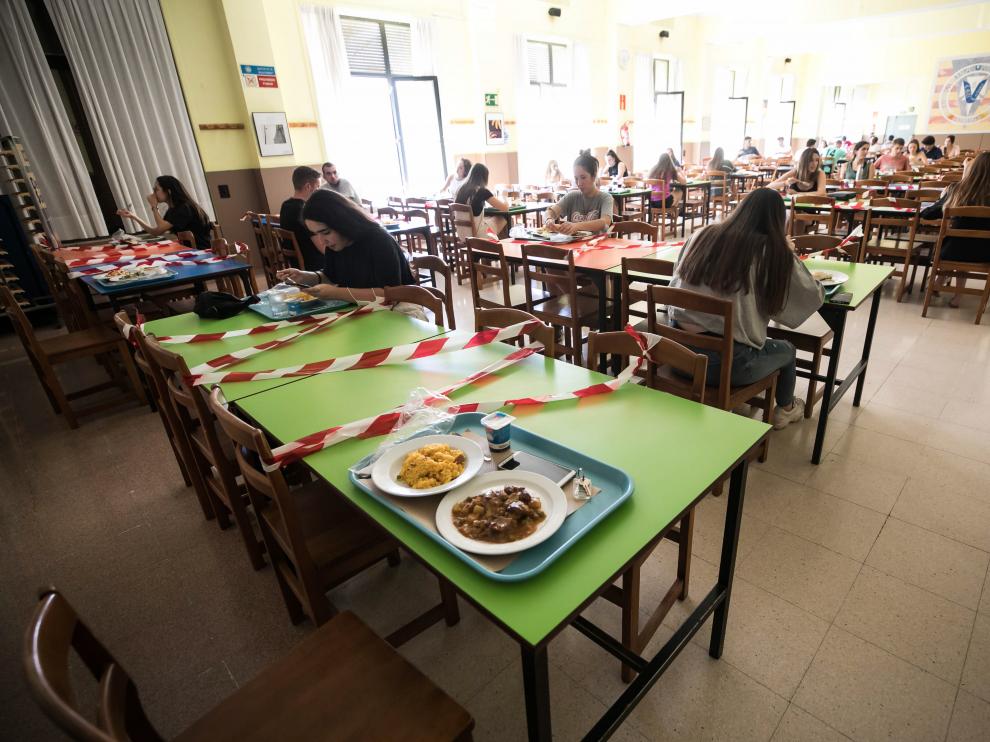 Las plazas de las mesas de comedor están marcadas con cintas de balizar en el comedor del colegio mayor Pedro Cerbuna de Zaragoza