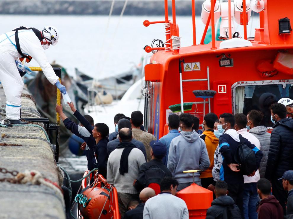 Un trabajador de Salvamento Marítimo reparte mascarillas en el puerto de Arguineguín, en Gran Canaria.