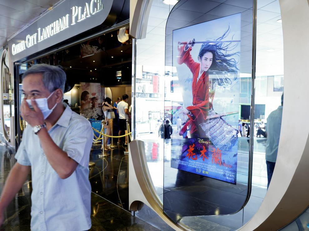 Un hombre pasa por un cine de Hong Kong donde se proyecta 'Mulan'