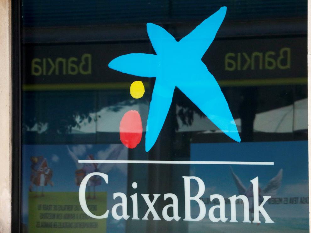 FILE PHOTO: Logos of Caixabank and Bankia are seen in bank offices near Barcelona