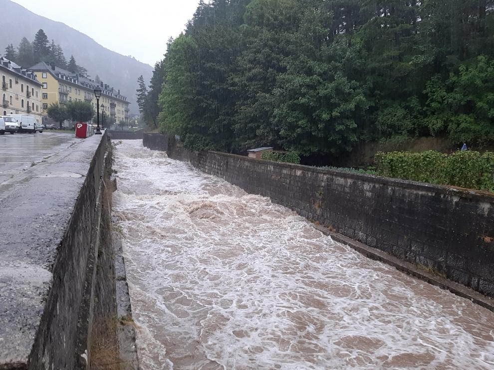 El río Aragón bajaba con fuerza este viernes a su paso por Canfranc por las intensas lluvias registradas en la zona.