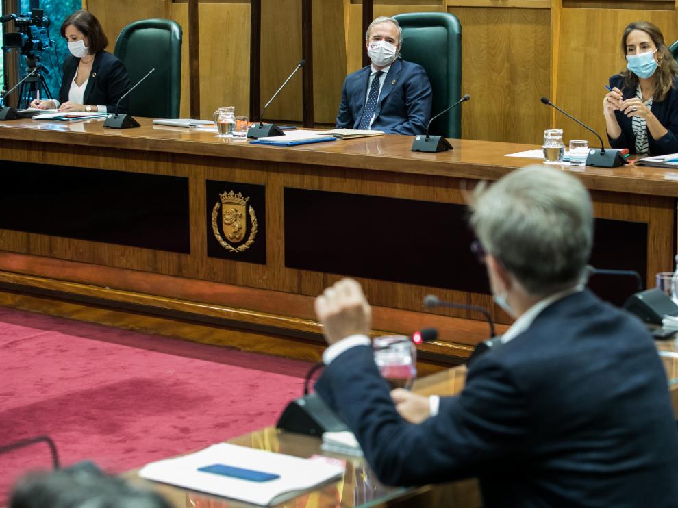 El alcalde de Zaragoza, Jorge Azcón, en el pleno municipal de este viernes, escucha al portavoz de ZEC, Pedro Santisteve.