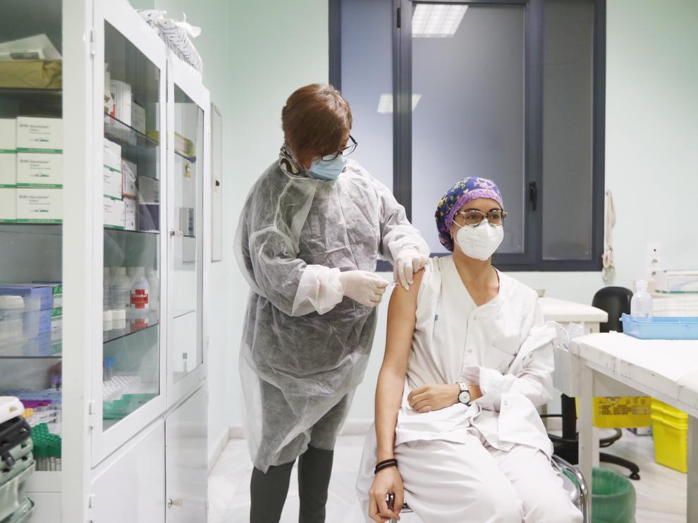 Una enfermera vacuna a una de las trabajadoras del centro de salud José Ramón Muñoz Fernández , en el paseo de Sagasta de Zaragoza.