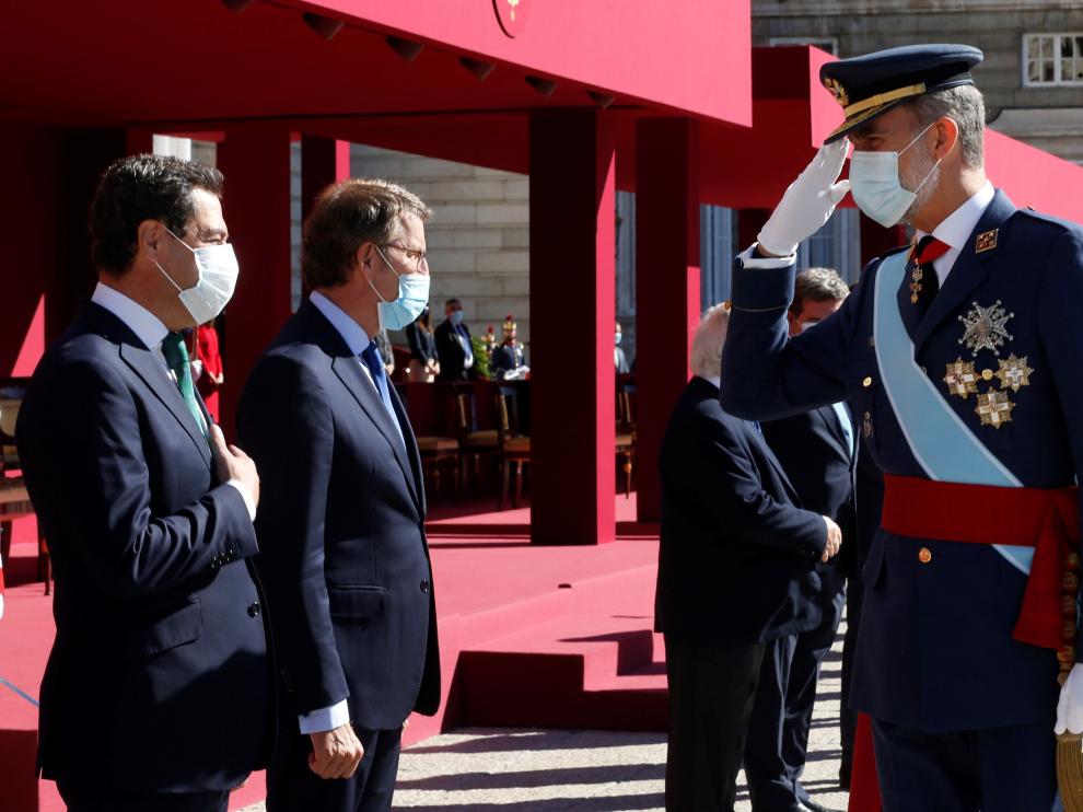 El Rey saluda al presidente de Andalucía, Juanma Moreno, durante el acto organizado con motivo del Día de la Fiesta Nacional, este lunes en Madrid.