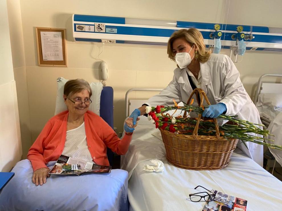 Una paciente ingresada en el Hospital San Juan de Dios recibe un clavel.
