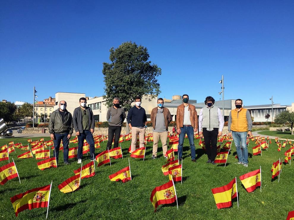 Representantes de la plataforma junto a las banderas colocadas en el parque Río Isuela.