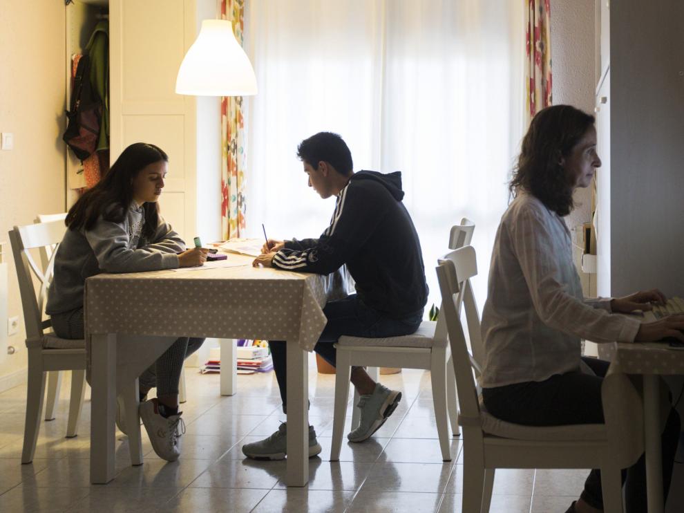 Tres aulas conviven en un único salón, donde la madre prepara una clase y los hijos estudian.