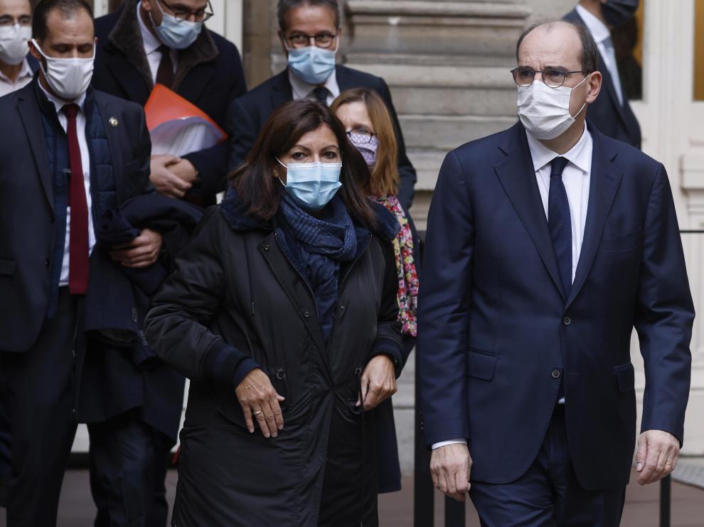 El primer ministro Jean Castex (derecha) junto a la alcaldesa de París, Anne Hidalgo, tras anunciar el toque de queda.