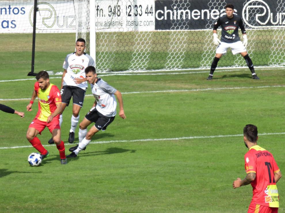 Un jugador del Ejea conduce el balón ante la presión de un defensa rival.