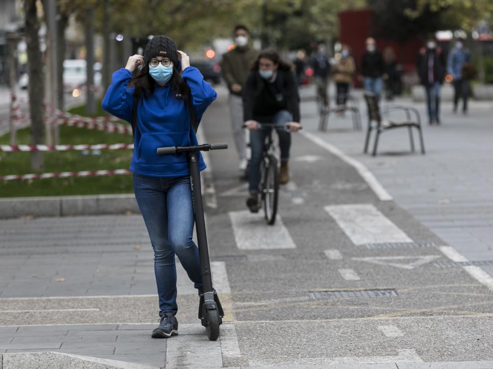 Una usuaria de patinete espera en un semáforo del carril bici de Fernando el Católico.