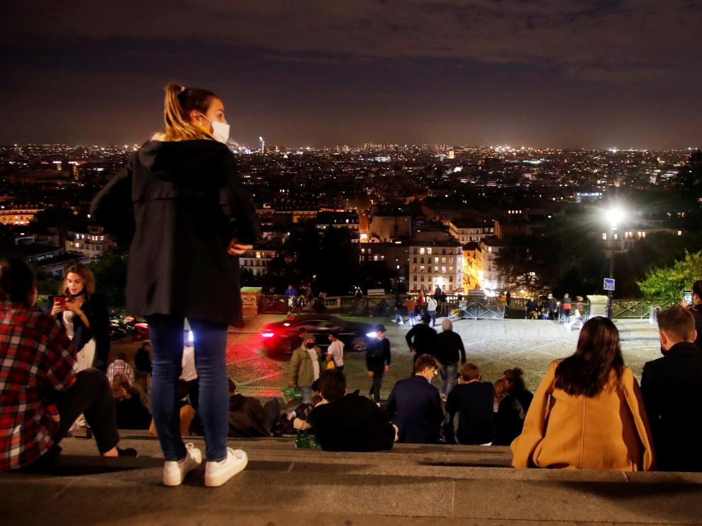 Varias personas disfrutan de las vistas de París, justo antes de las doce, hora a la que en Francia entra en vigor el toque de queda.