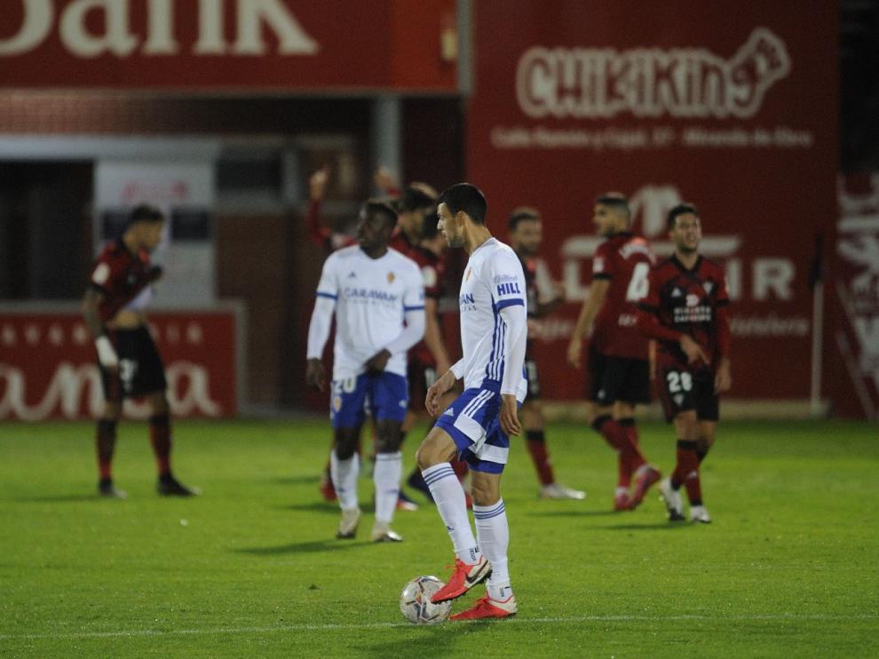 Los futbolistas del Mirandés celebran al fondo su gol ganador en la última jugada, en el minuto 93. Nick y Vuckic, con cara de circunstancias, sufren el varapalo.