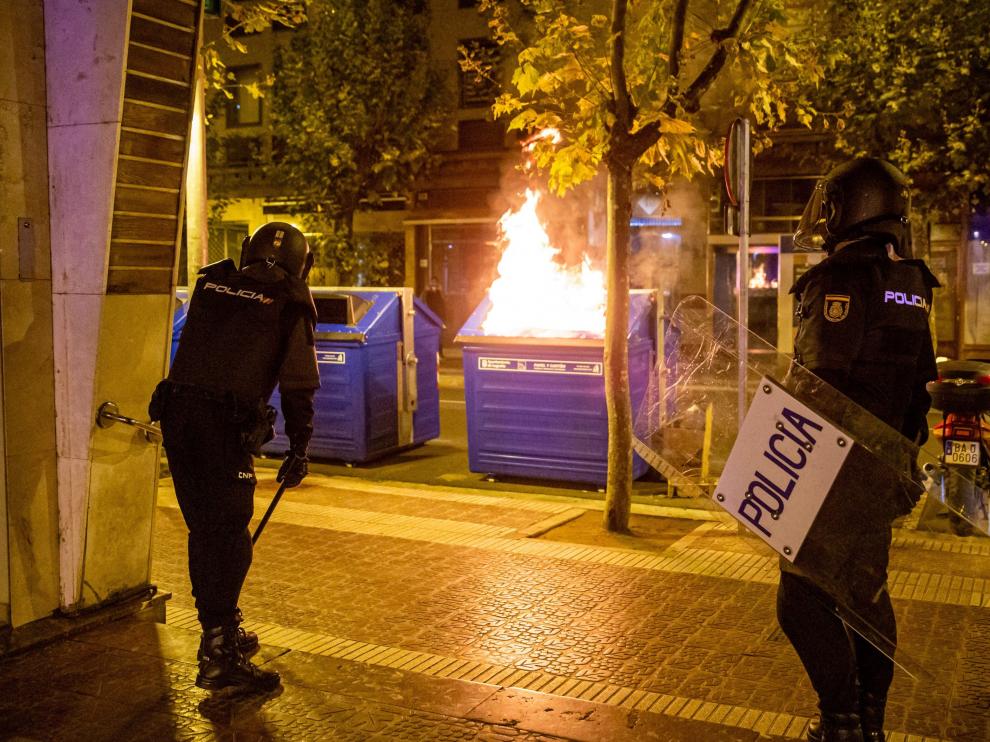 Agentes de la Policía, junto a un contenedor incendiado en Logroño.