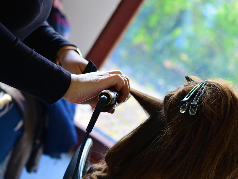 Imagen de una peluquera peinando a una clienta.